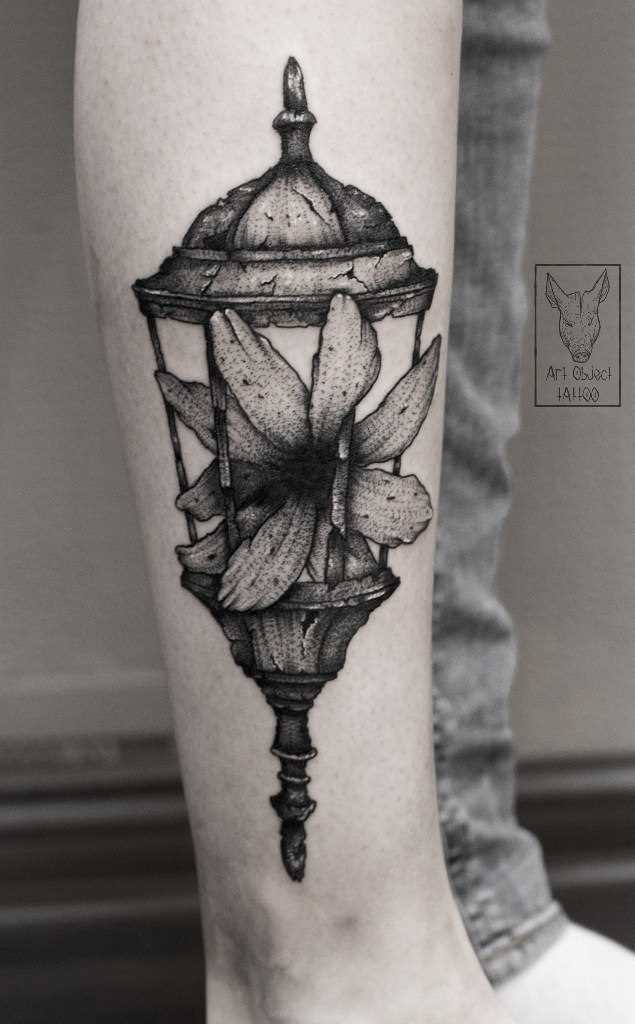 A flor e a lanterna de - tatuagem na perna da menina