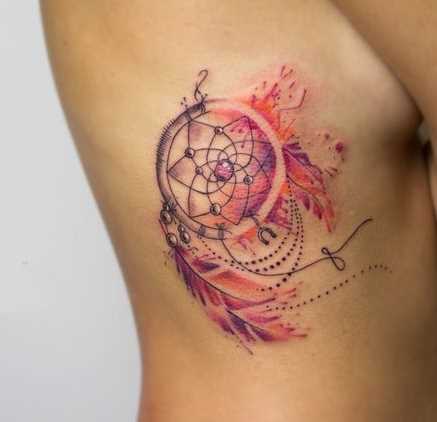 A foto da tatuagem de apanhador de sonhos em estilo de aquarela sobre as costelas menina