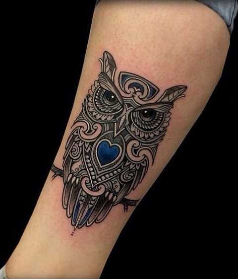 A foto da tatuagem de coruja em um estilo gráfico sobre a perna da menina