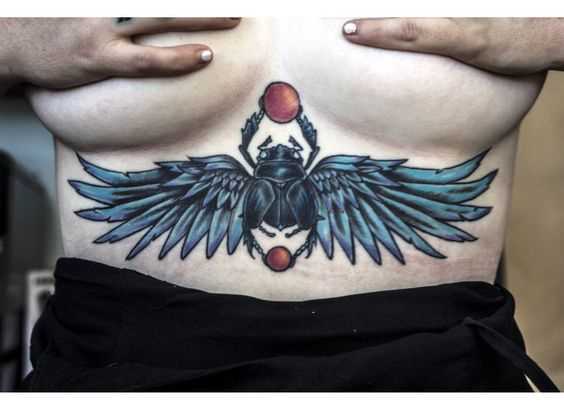 A foto da tatuagem de escaravelho em estilo egípcio no peito da menina