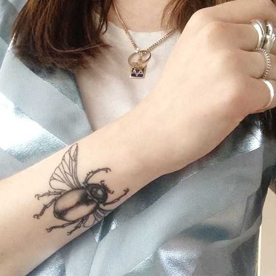 A foto da tatuagem de escaravelho em estilo egípcio no pulso da menina