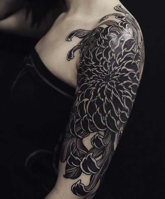 A foto da tatuagem de flor no estilo de blackwork no ombro da menina