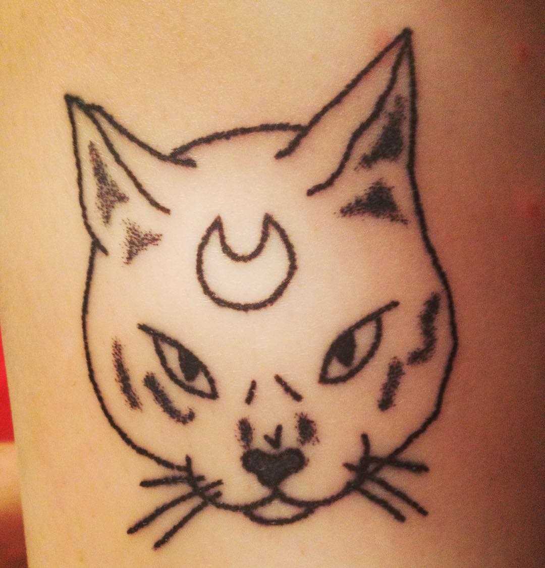 A foto da tatuagem de gato em grande estilo handpoke na mão de um cara