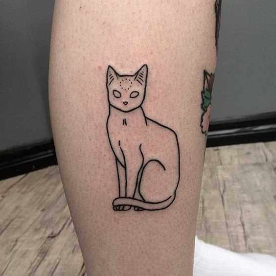 A foto da tatuagem de gato em grande estilo handpoke sobre a perna da menina
