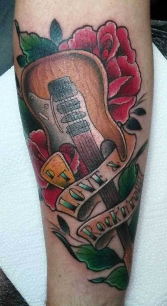 A foto da tatuagem de guitarra no estilo newschool no antebraço cara