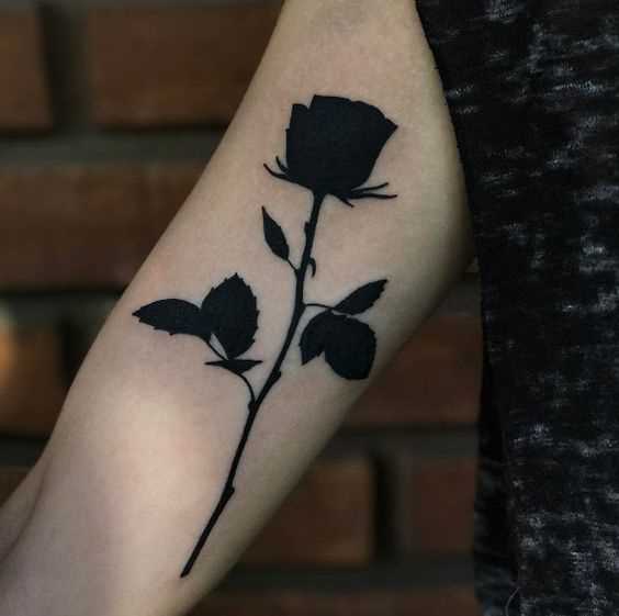 A foto da tatuagem de rosas no estilo blackwork na mão da menina