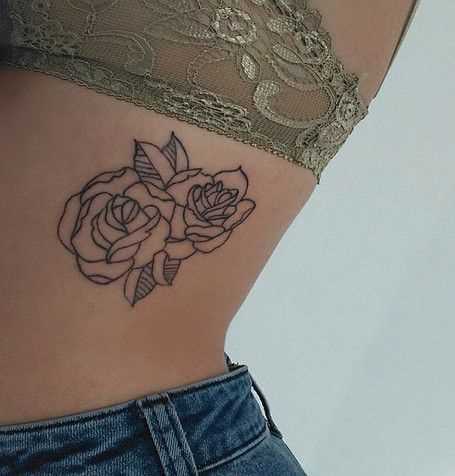 A foto da tatuagem de rosas no estilo handpoke sobre as costelas menina