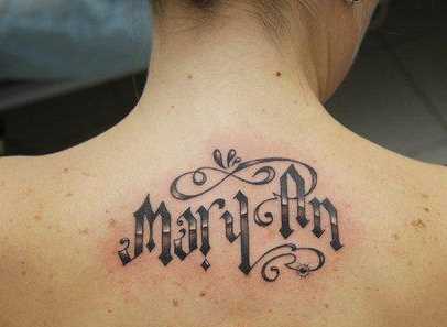 A foto da tatuagem de texto em estilo gótico na parte de trás da menina