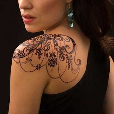 A foto da tatuagem de um padrão de estilo gótico no ombro da menina