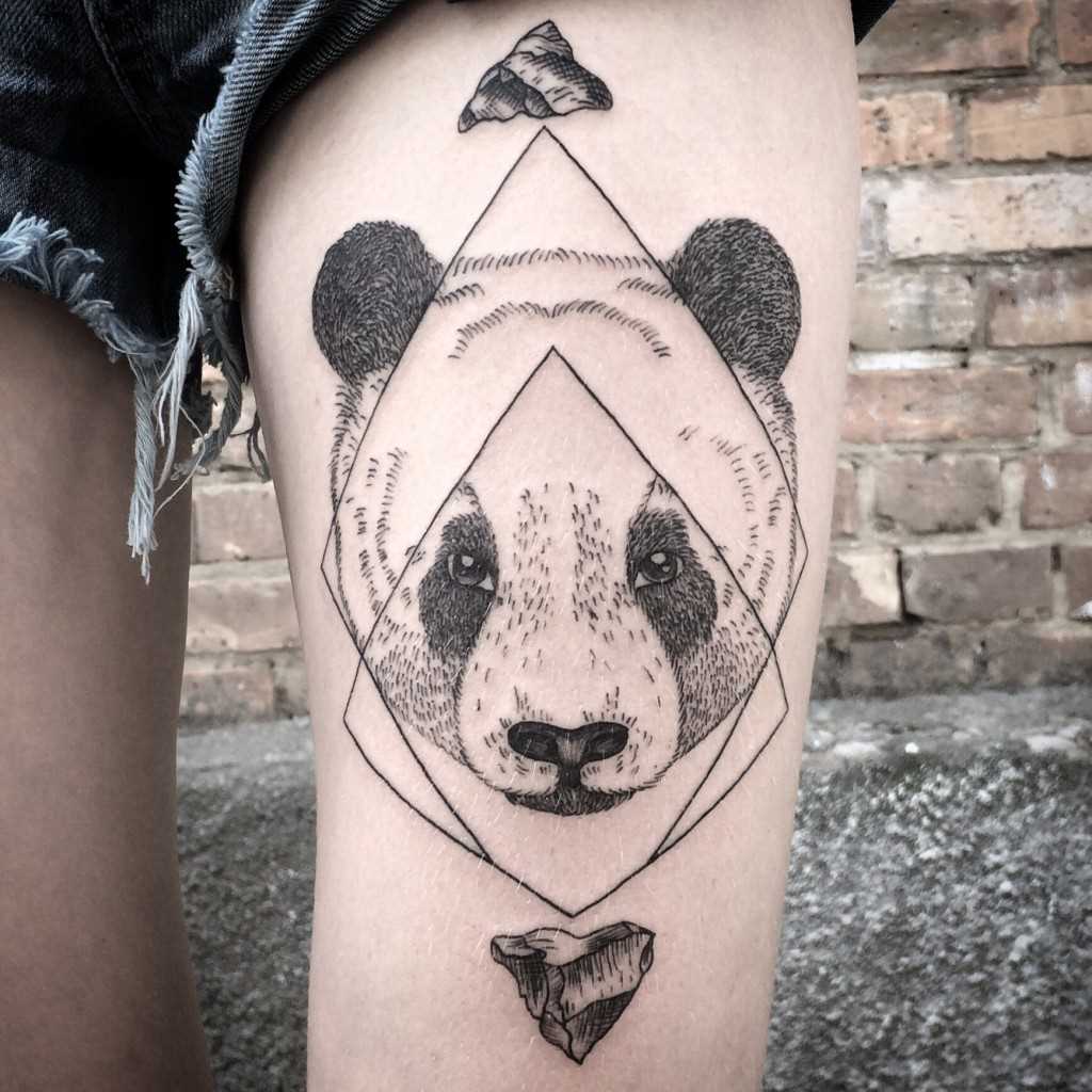 A foto da tatuagem de um panda no estilo de gráfico no quadril da menina