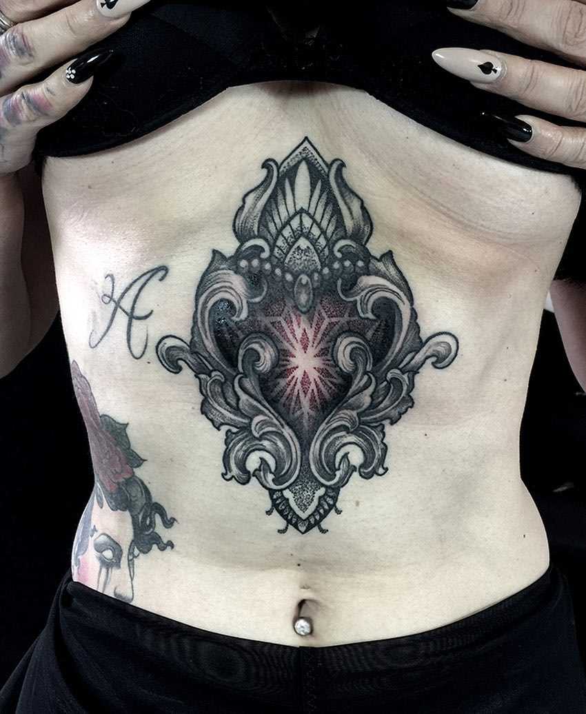 A foto de uma bela tatuagem em estilo barroco na barriga da menina