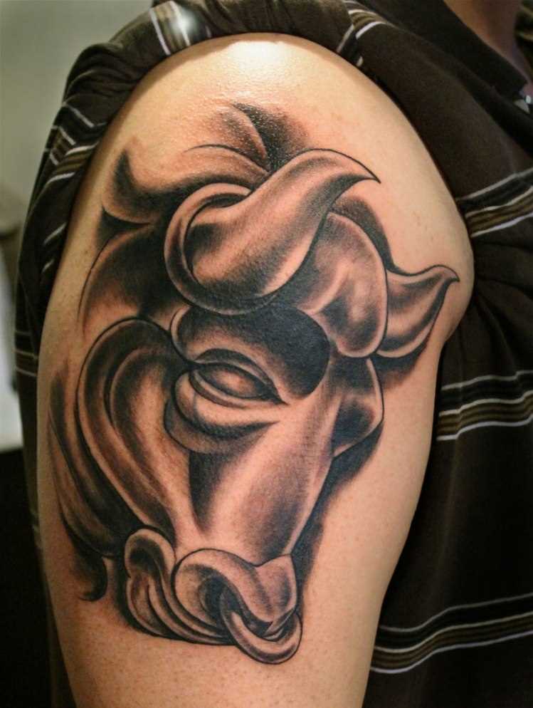 A grande tatuagem que um cara no ombro em forma de uma cabeça de touro