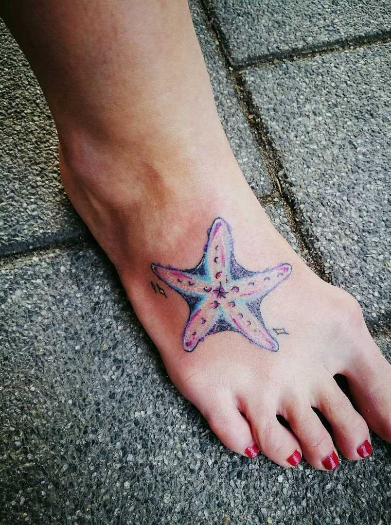 A imagem da estrela do mar na planta do pé da menina