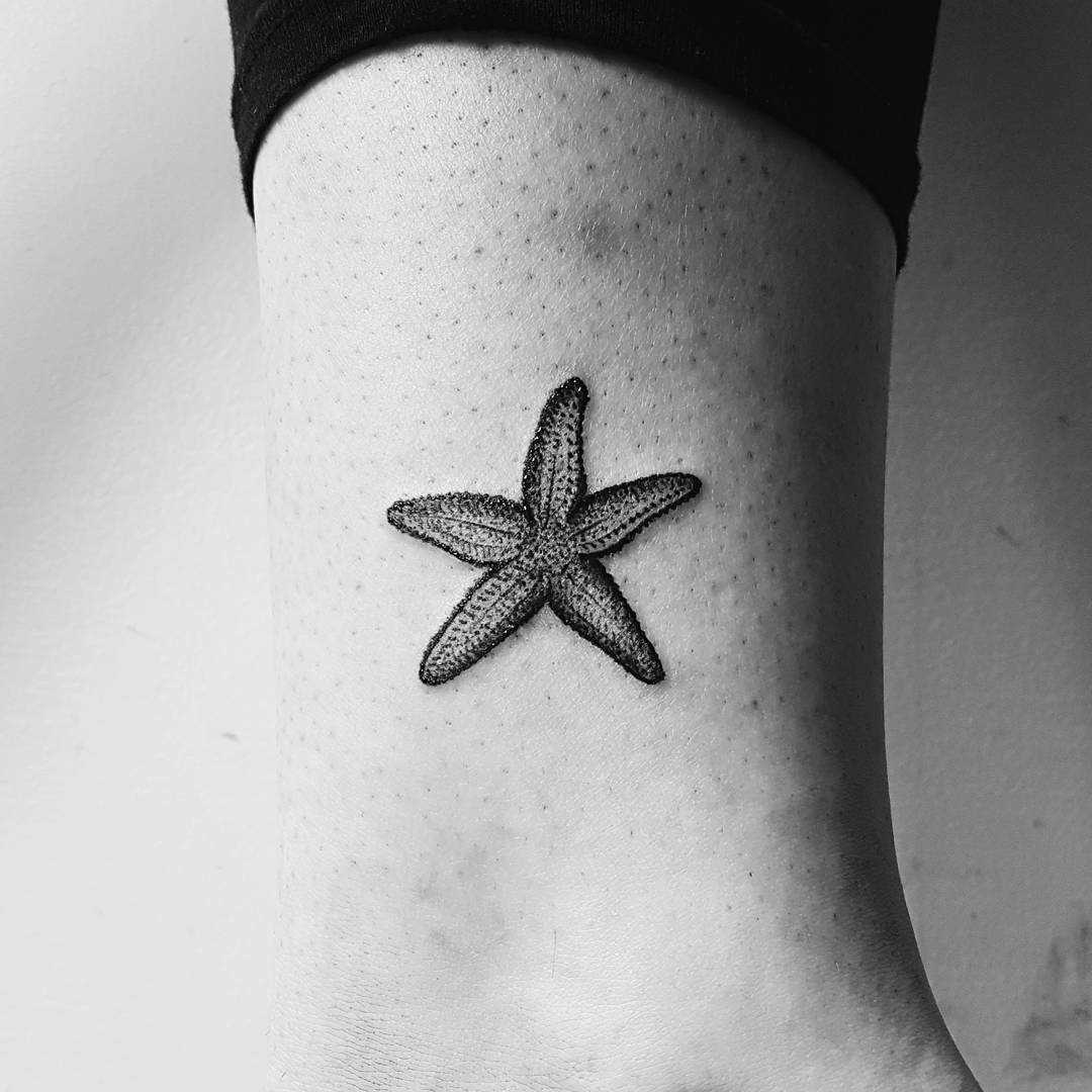 A imagem da estrela do mar sobre a perna da mulher