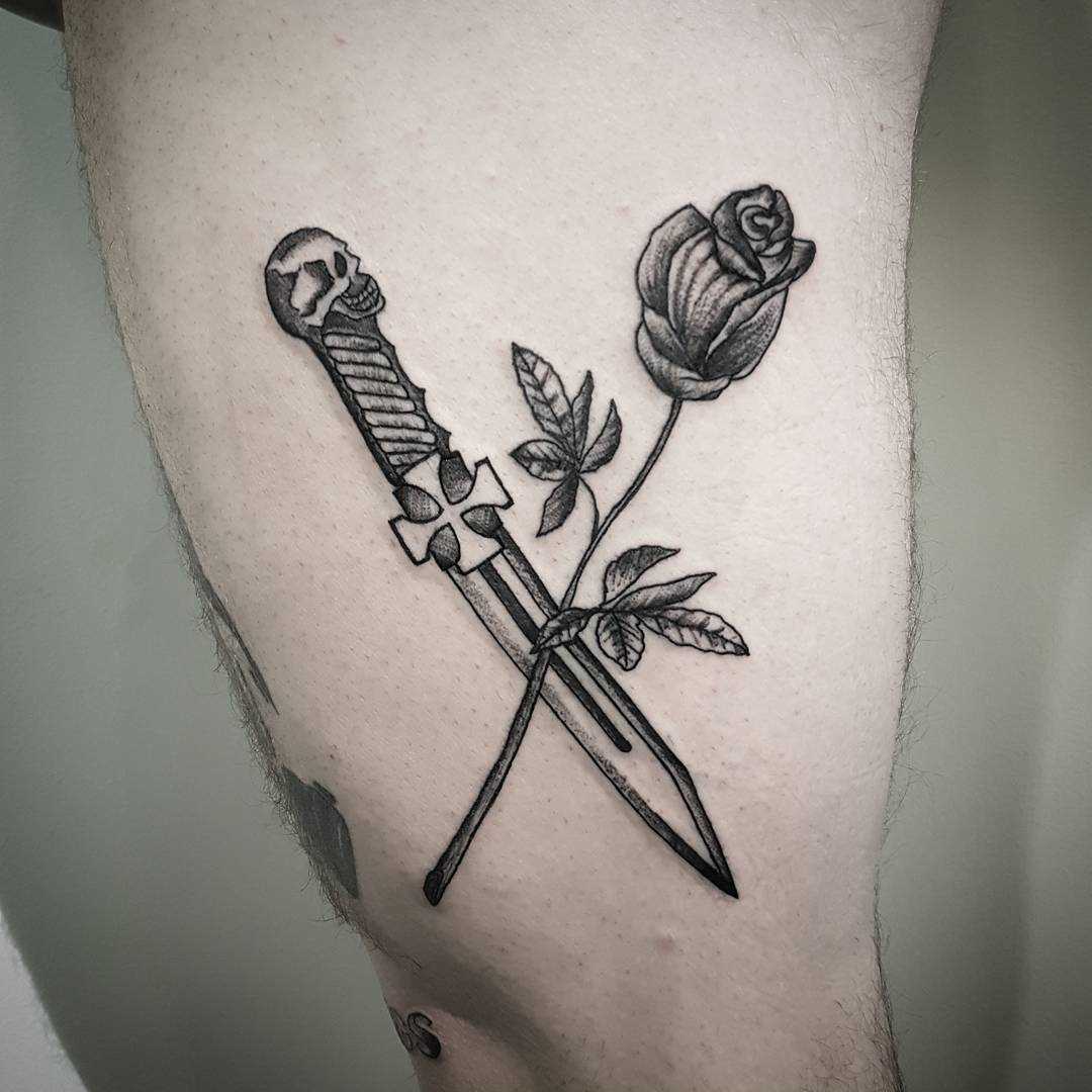 A imagem da faca com uma rosa na coxa homens