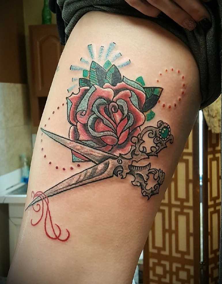 A imagem da tesoura com uma rosa no antebraço da menina