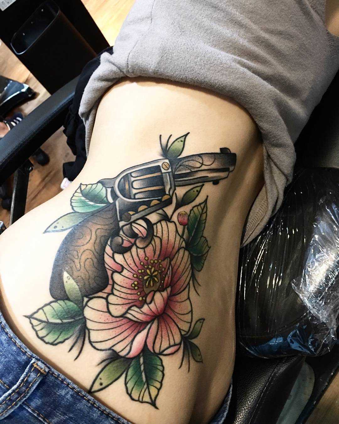 A imagem do revólver com a flor na lateral da menina