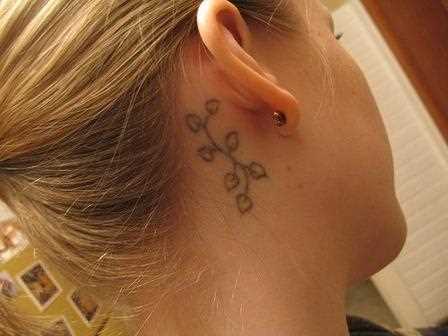 A tatuagem atrás da orelha, no pescoço da menina - folhas