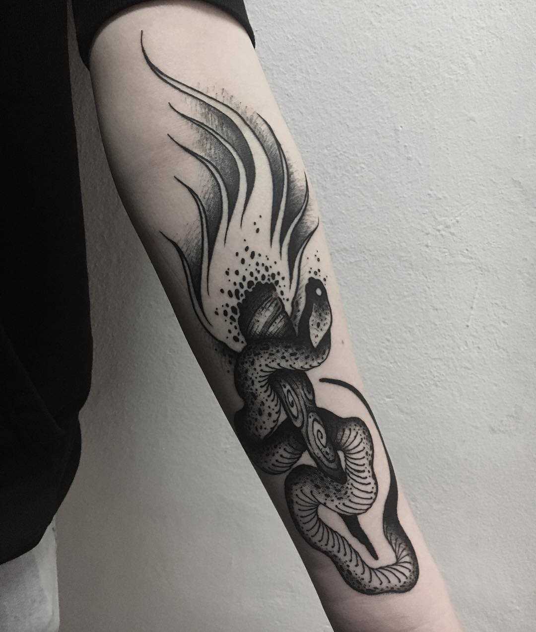 A tatuagem da tocha com uma cobra no antebraço cara