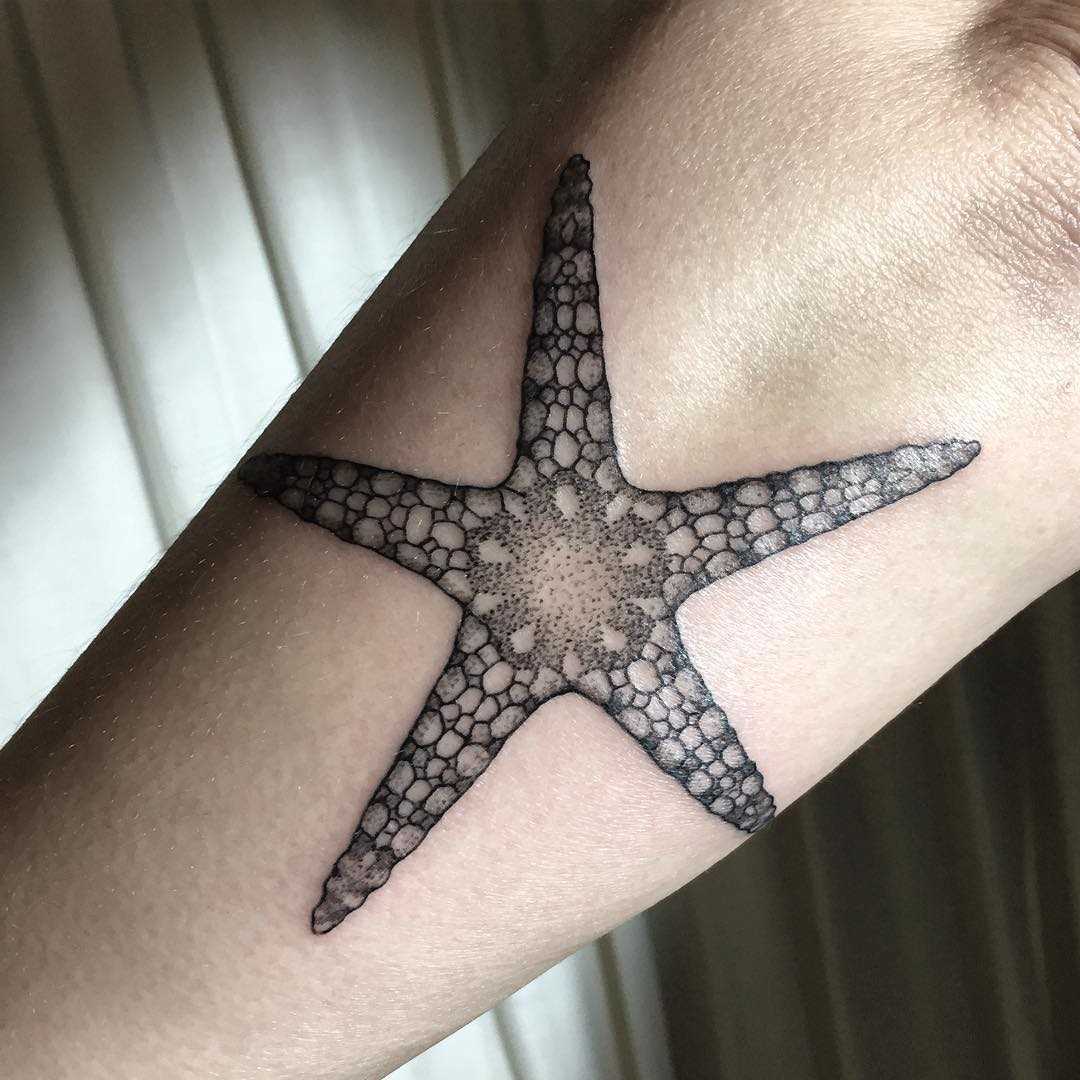 A tatuagem de estrela no antebraço da mulher