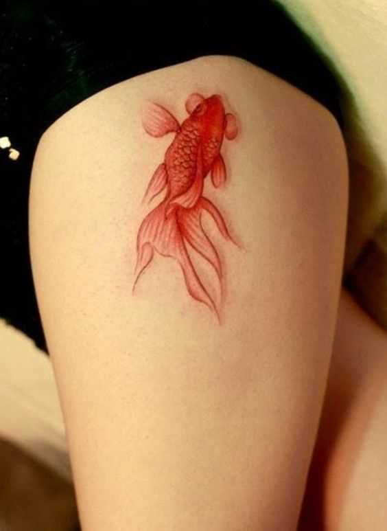 A tatuagem de peixe de ouro no quadril da menina