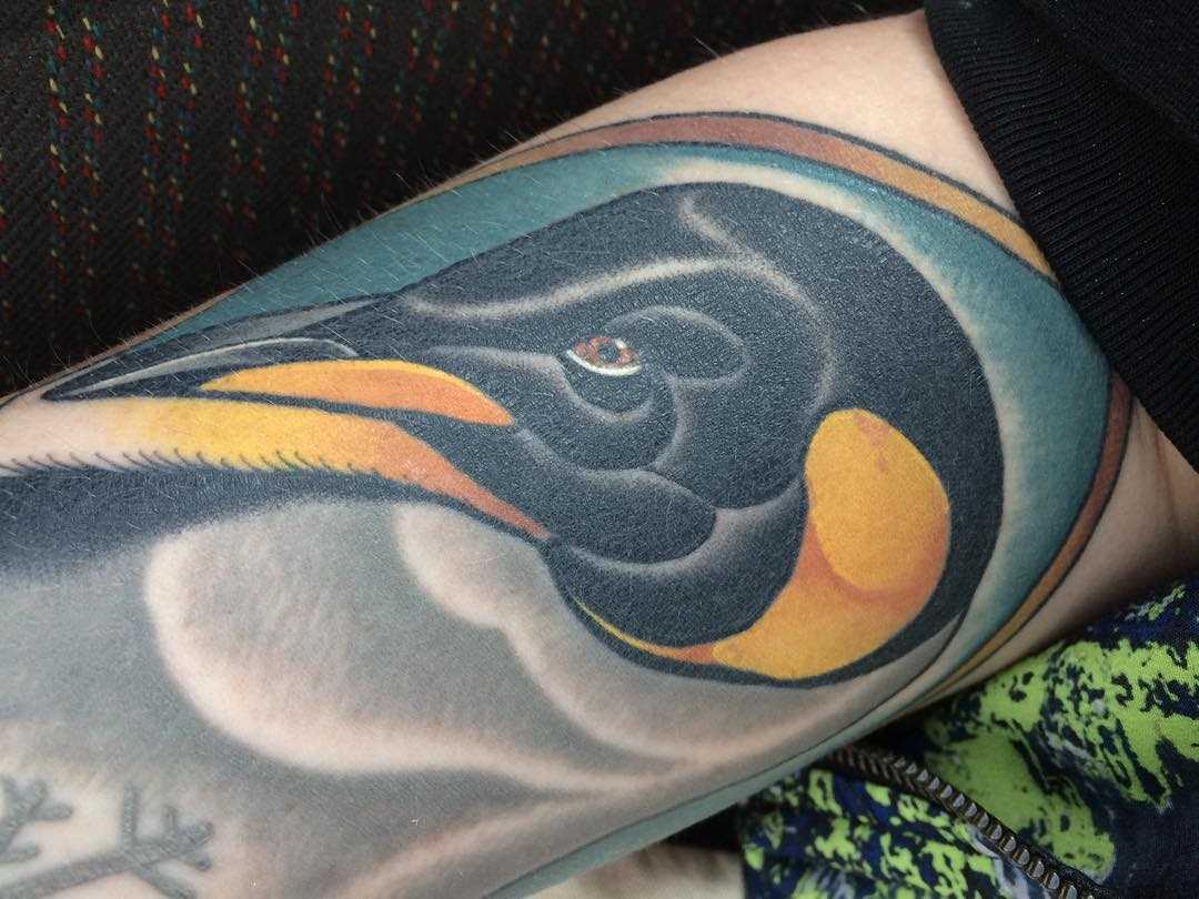 A tatuagem de pinguim na mão de um cara