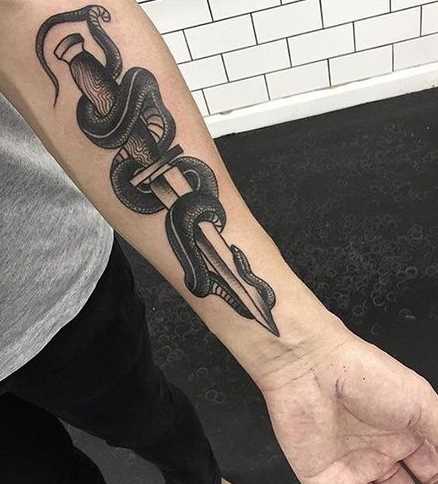 A tatuagem de uma faca com uma cobra no antebraço cara
