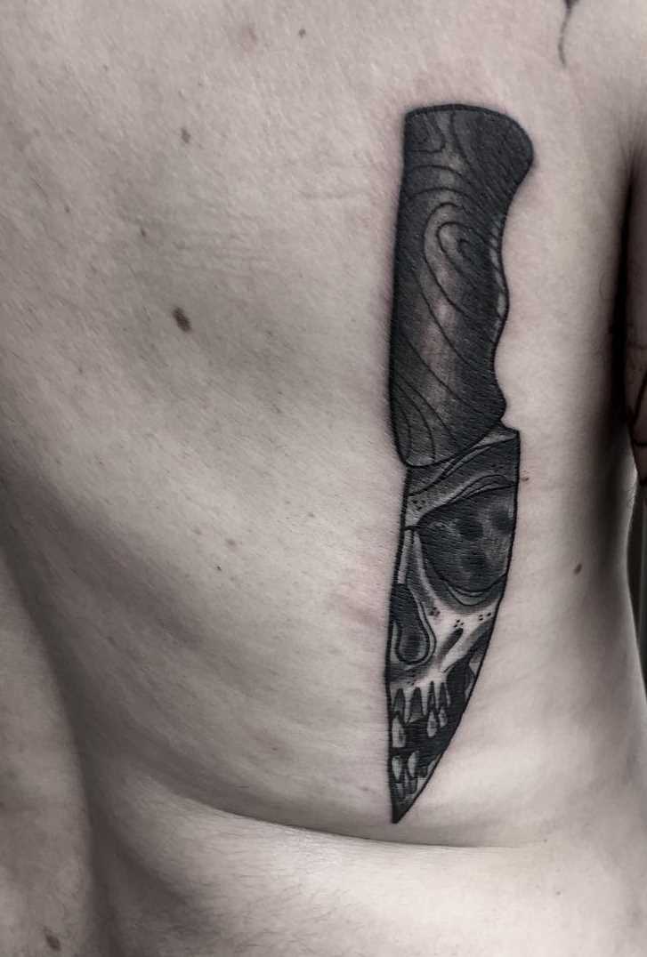 A tatuagem de uma faca nas costas de homens