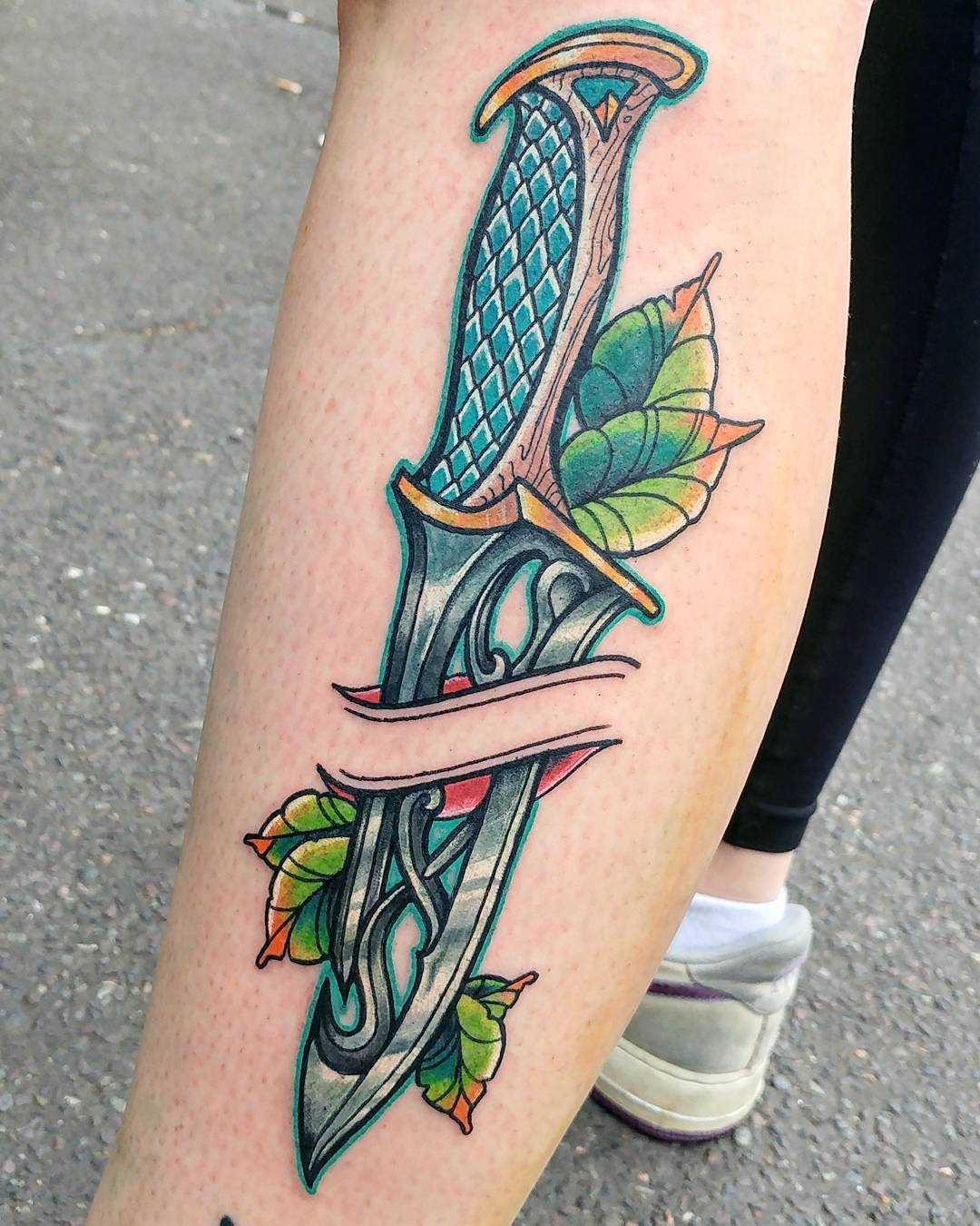 A tatuagem de uma faca sobre a perna da menina