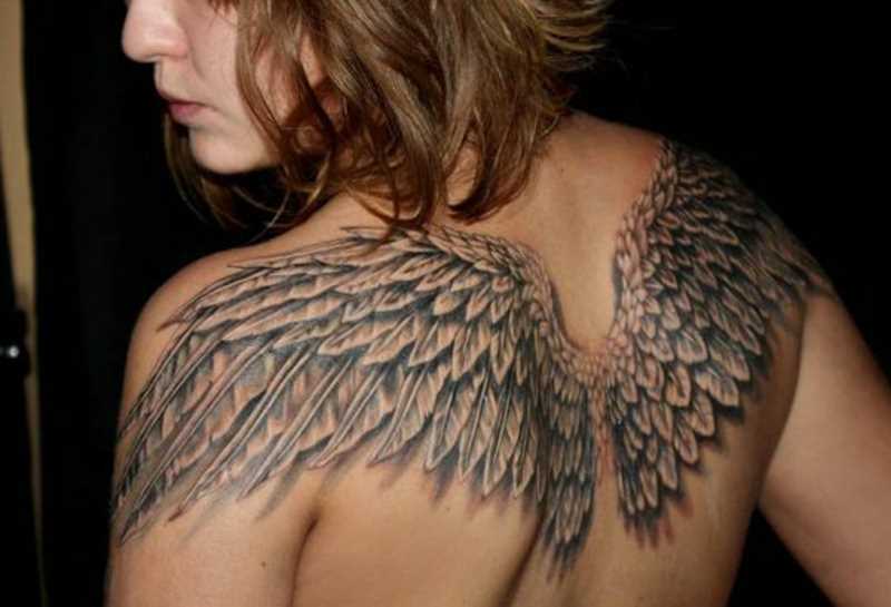 A tatuagem de uma menina de costas com a imagem de asas