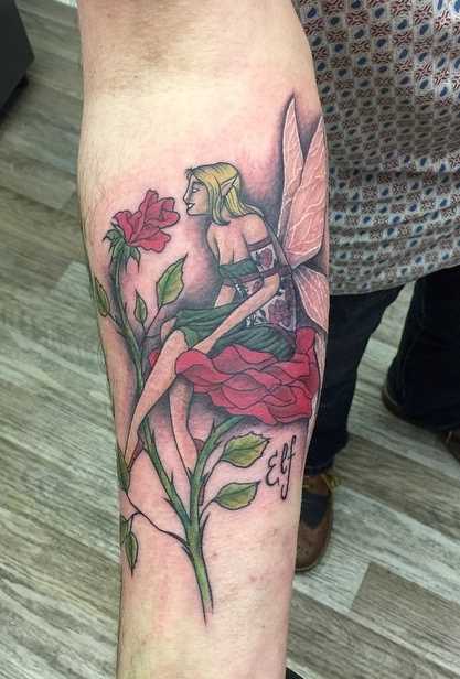 A tatuagem de uma menina elfo com flores no antebraço homens