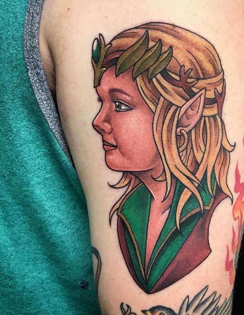 A tatuagem de uma menina elfo no ombro de homens