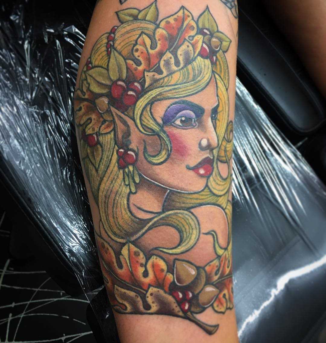 A tatuagem de uma menina elfo sobre a perna da mulher