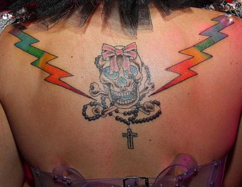 A tatuagem de uma menina em lâminas de correr e o crânio com um amigo.
