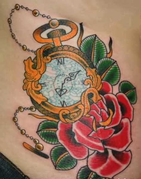 A tatuagem de uma menina na região lombar - um relógio de bolso e rosa