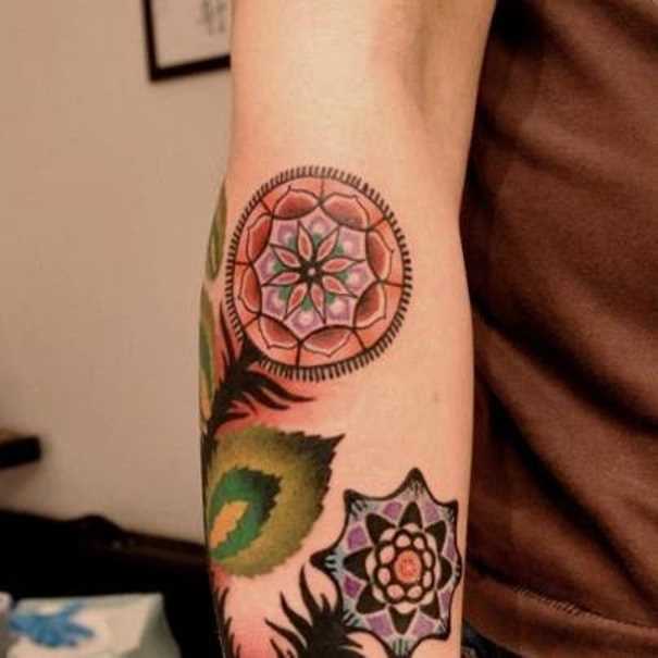 A tatuagem de uma menina no antebraço - mandala em forma de flor