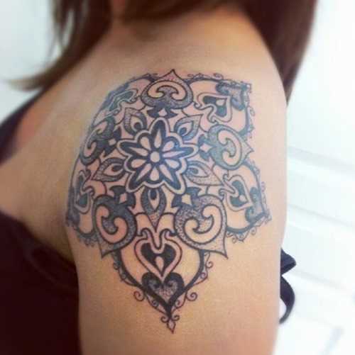 A tatuagem de uma menina no ombro em forma de mandala