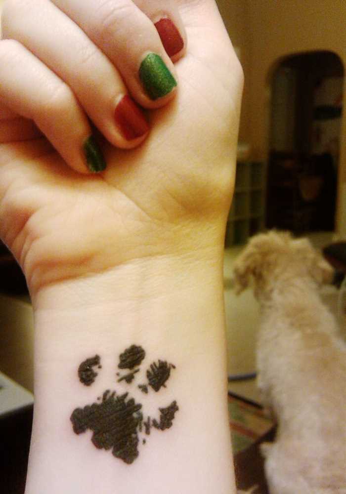A tatuagem de uma menina no pulso - pata do cão