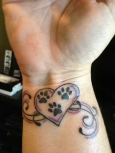 A tatuagem de uma menina no pulso - pata e o coração
