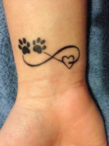 A tatuagem de uma menina no pulso - pata, o símbolo do infinito e o coração