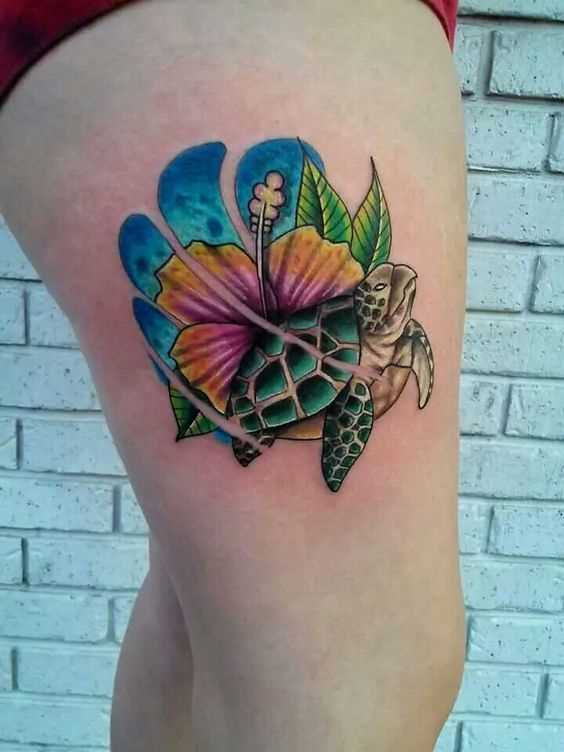 A tatuagem de uma tartaruga, com uma flor no quadril da menina