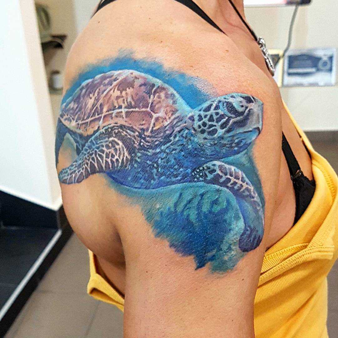 A tatuagem de uma tartaruga no ombro da menina