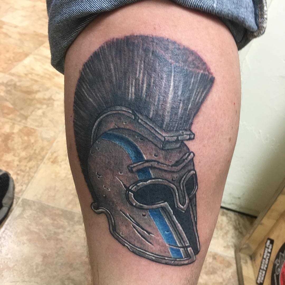 A tatuagem do capacete spartan sobre a perna de homens