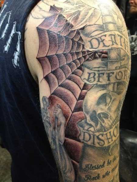 A tatuagem do cara no ombro com a imagem da web, do crânio e inscrições