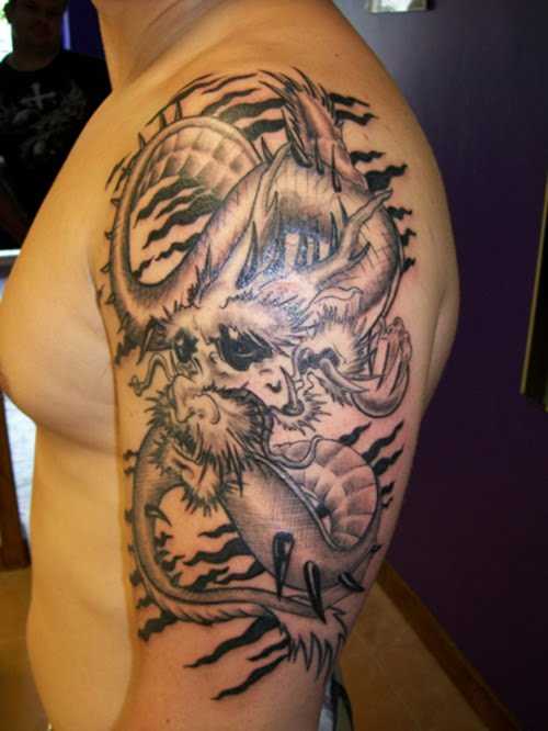 A tatuagem do cara no ombro com a imagem de um dragão