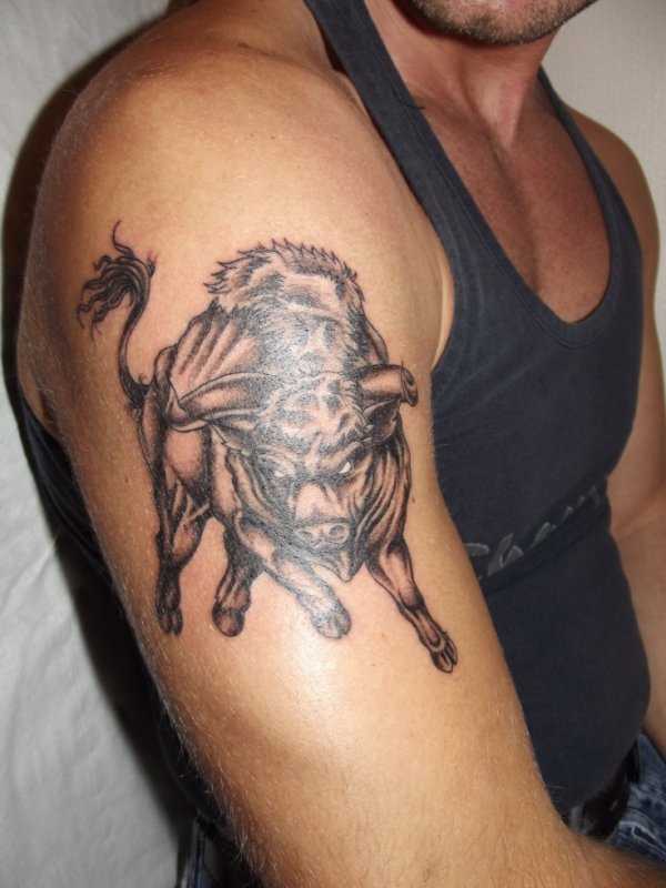 a tatuagem do cara no ombro com a imagem de um mal touro
