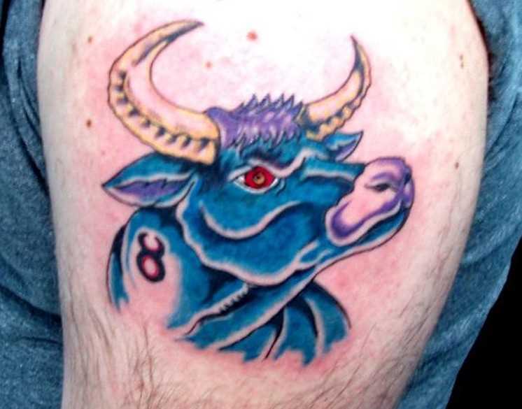 A tatuagem do cara no ombro com a imagem de um touro azul