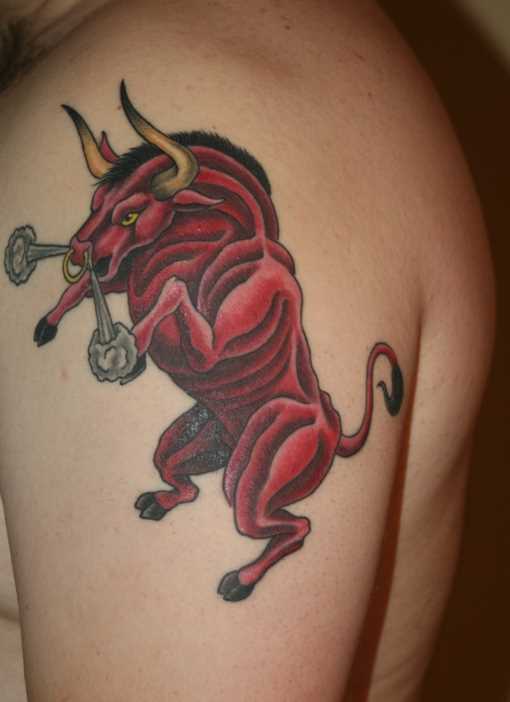 A tatuagem do cara no ombro como um touro vermelho