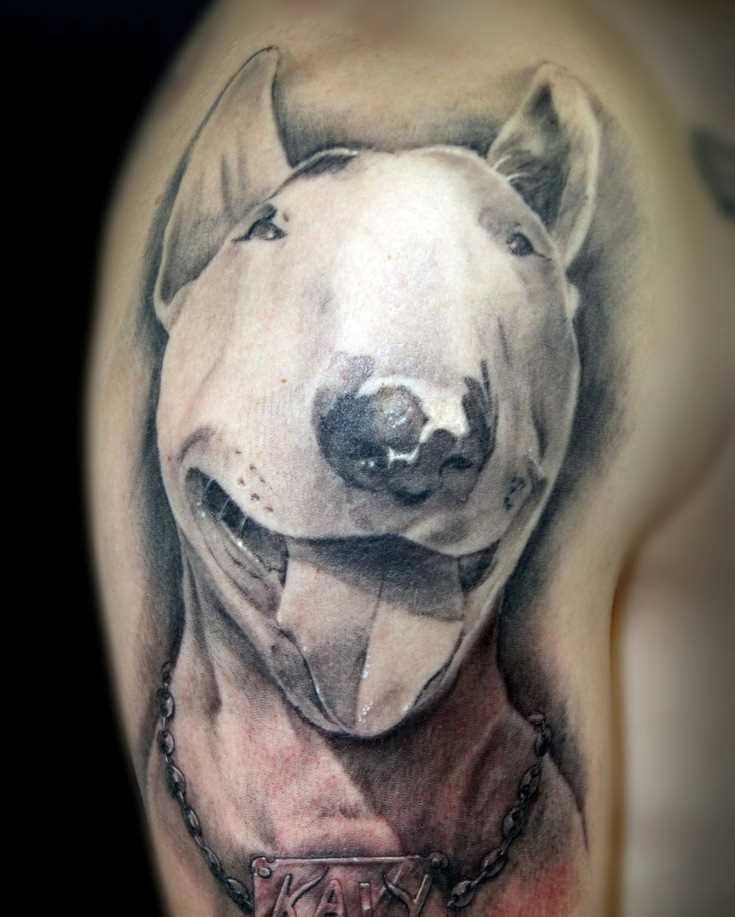A tatuagem do cara no ombro em forma de cão