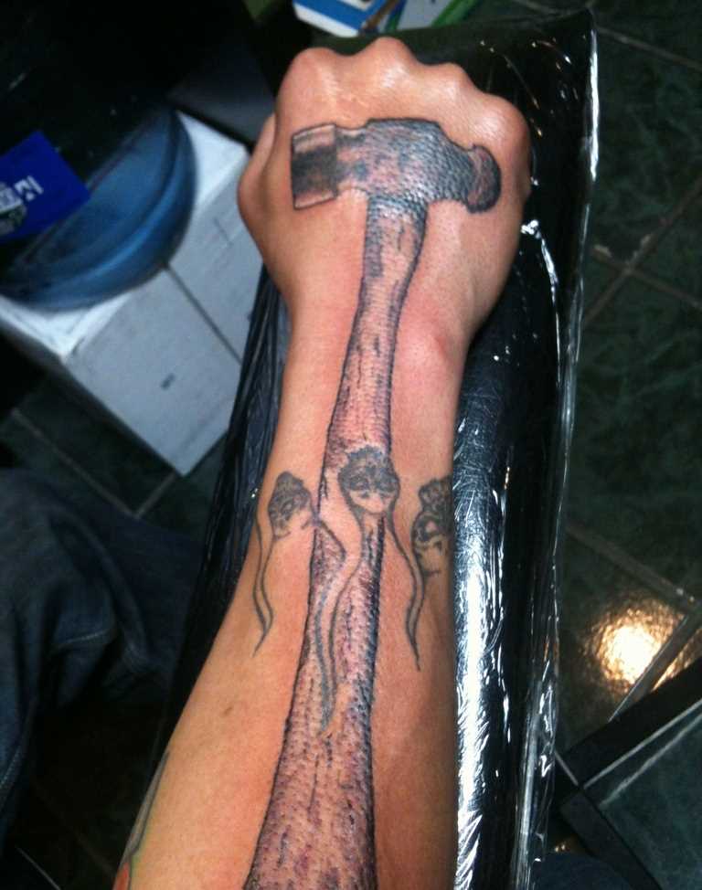 A tatuagem do cara no pincel e antebraço - martelo